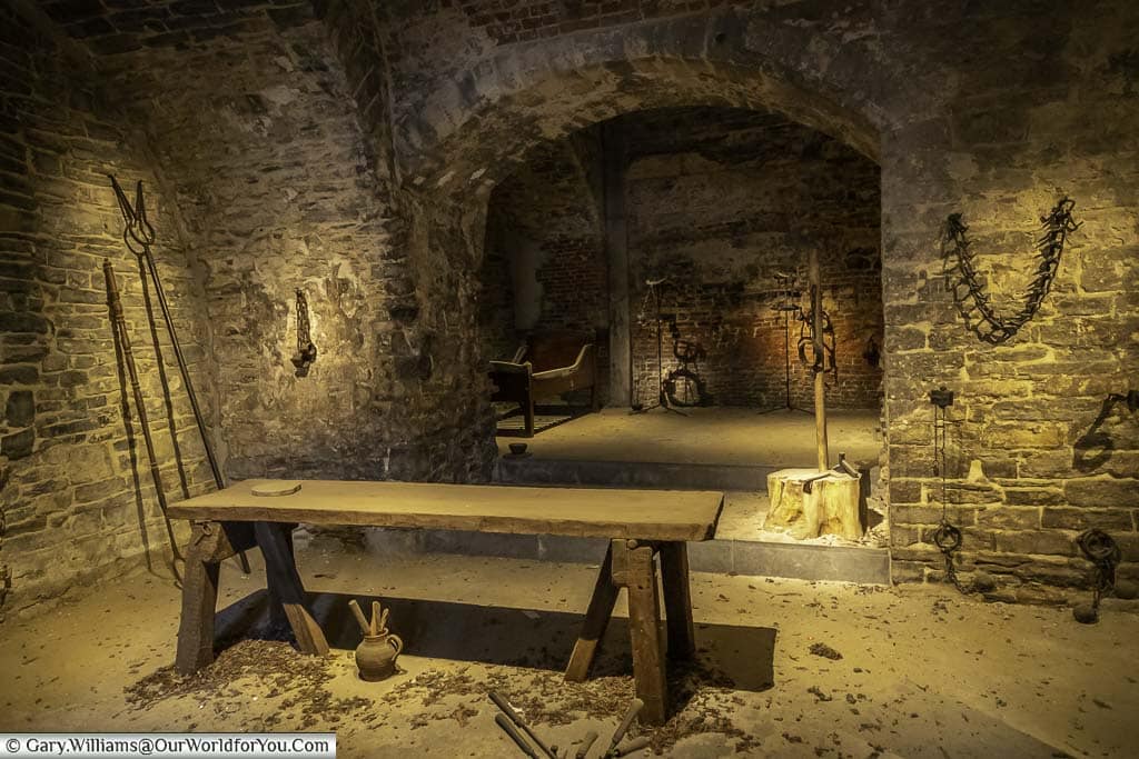 A wooden table and instruments of tourture in the dungeon of the Castle of the Counts in ghent, belgium