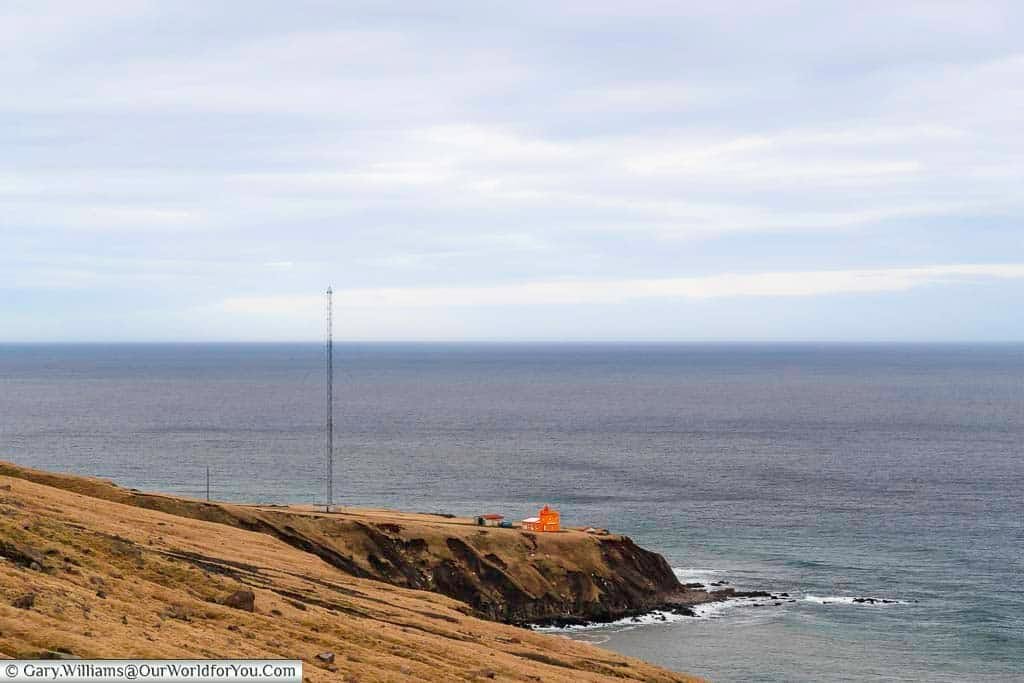 The orange Trollaskagi Lighthouse on a bleak outcrop of rock in Northern Iceland