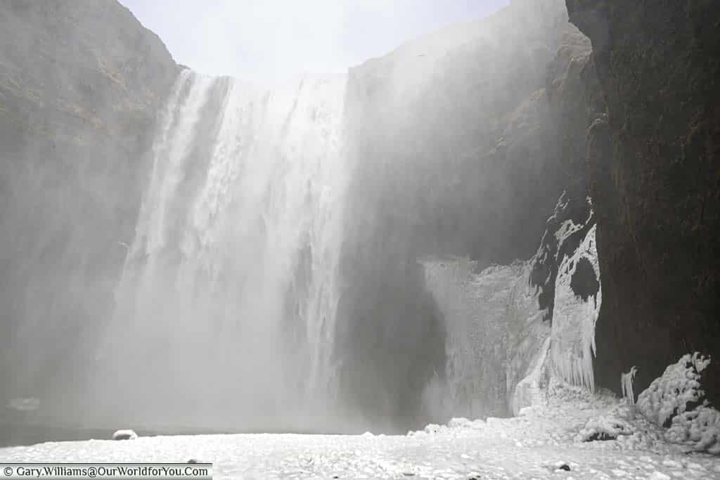 Close up to the base of the Skógafoss waterfall in iceland on an icy day in March