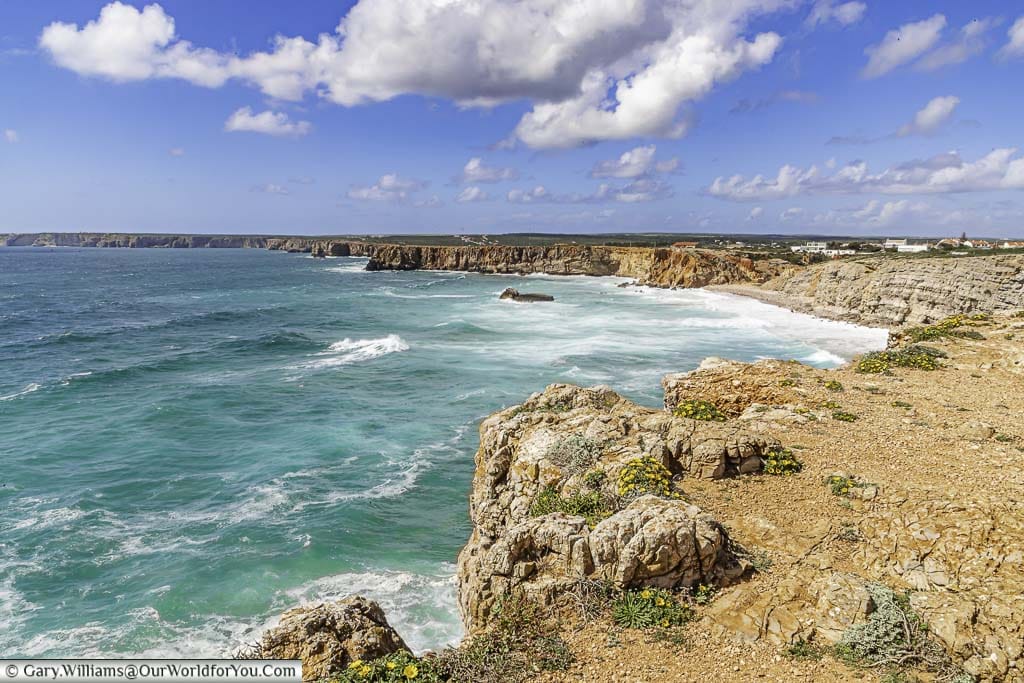 Waves crashing against the rocky coastline of Sangres on the Algarve, the southernmost point on our portuguese road trip