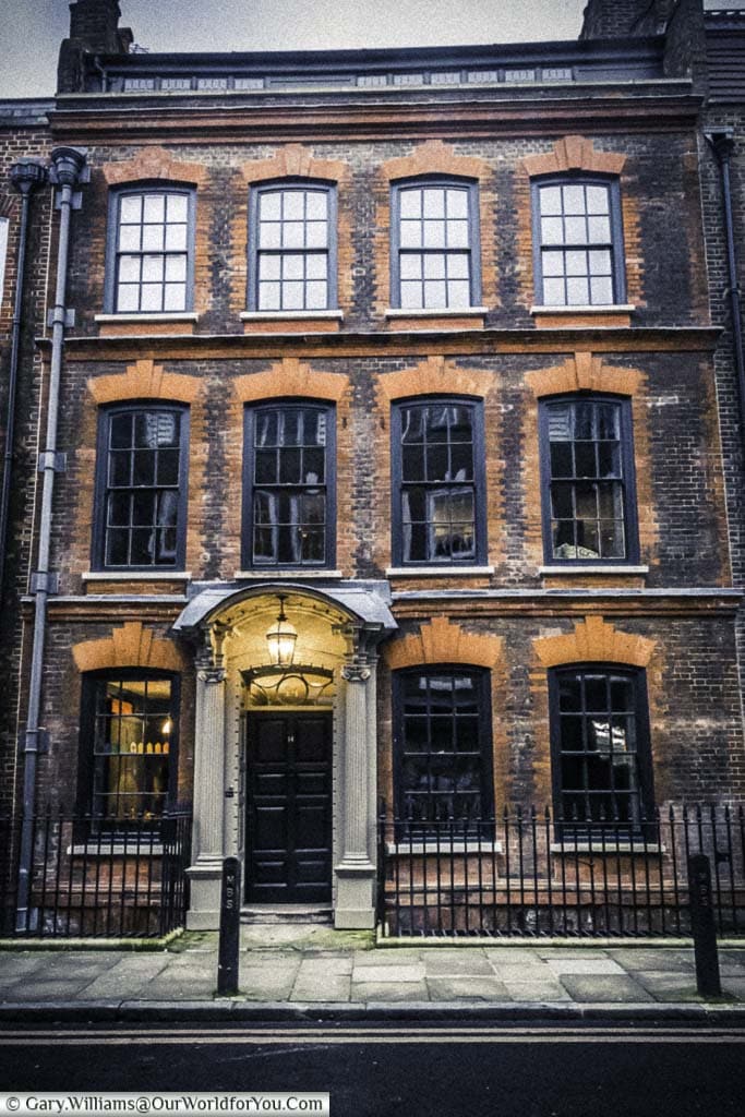 14 Fournier Street, leading away from Spitalfields is a 3 storey brick-built terraced building with a grand entrance lit by a hanging Georgian lantern.
