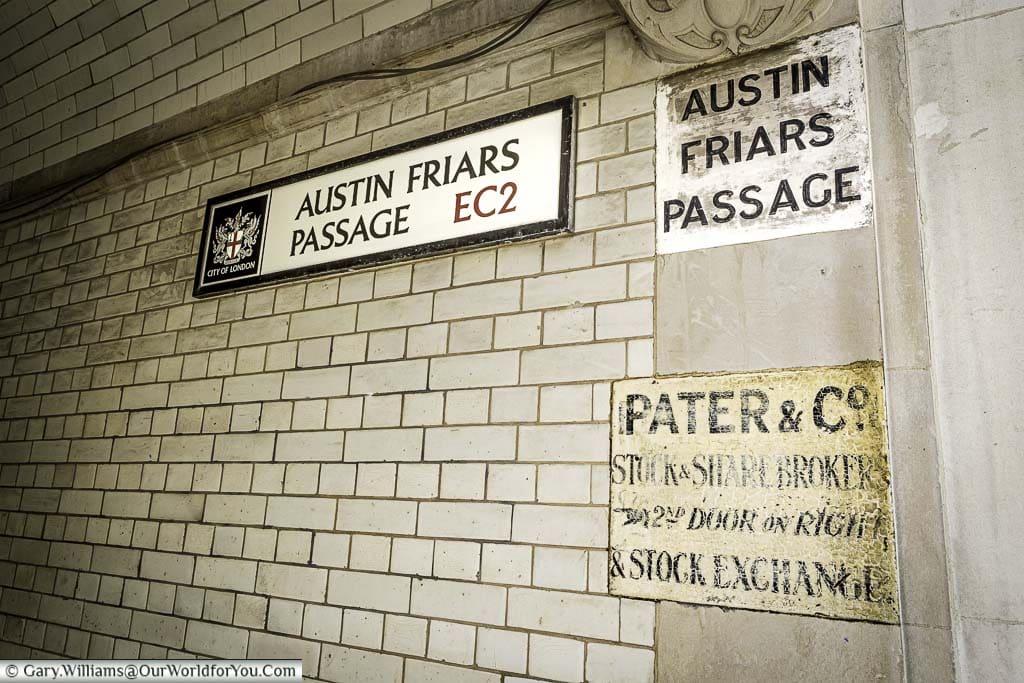 A sign for Austin Friars Passage, on the tiled alleyway, in the city of London.