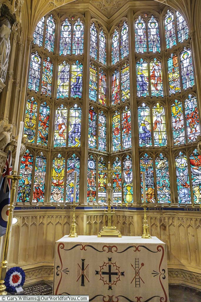 The ornate stained glass window behind a small altar in the RAF chapel in westminster abbey in london