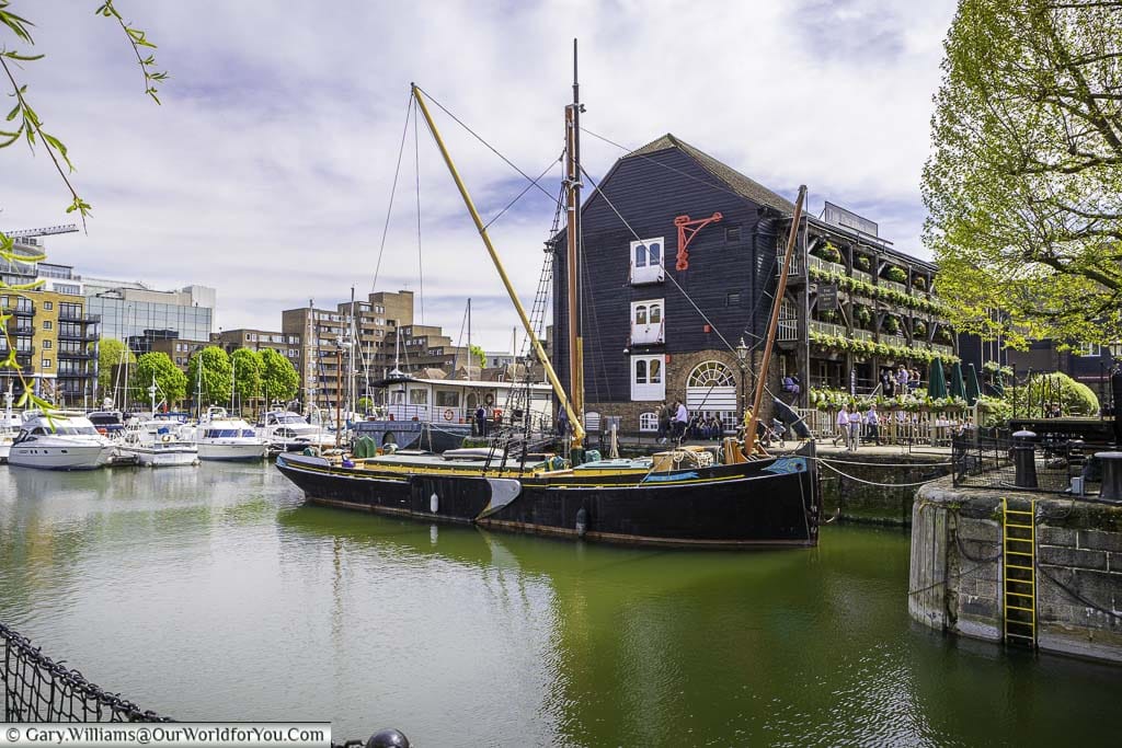 A sailing barge moored in front of the Dickens Inn at St Katharine docks