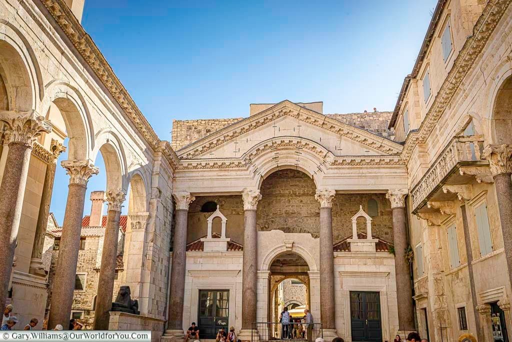 Standing in the central courtyard of the Diocletian palace in Split, Croatia, bathed in the golden light of late afternoon under deep blue skies.