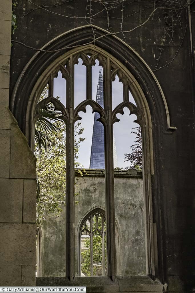 View through the window of a derelict church to the Shard skyscraper in the City of London