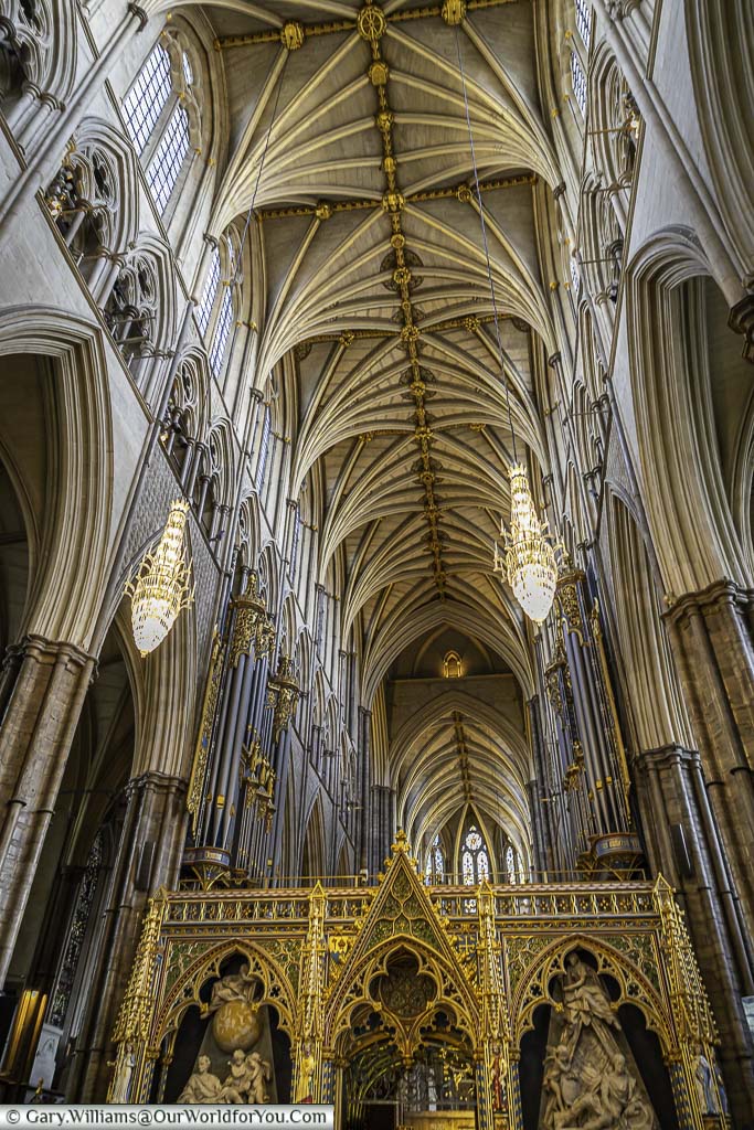 A view of Westminster Abbey Nave and Quire screen leading up to the ornate vaulted roof.