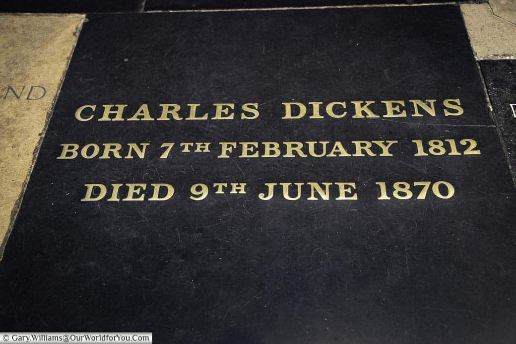 The engraved stone above charles dickens grave in the poets corner section of westminster abbey in london
