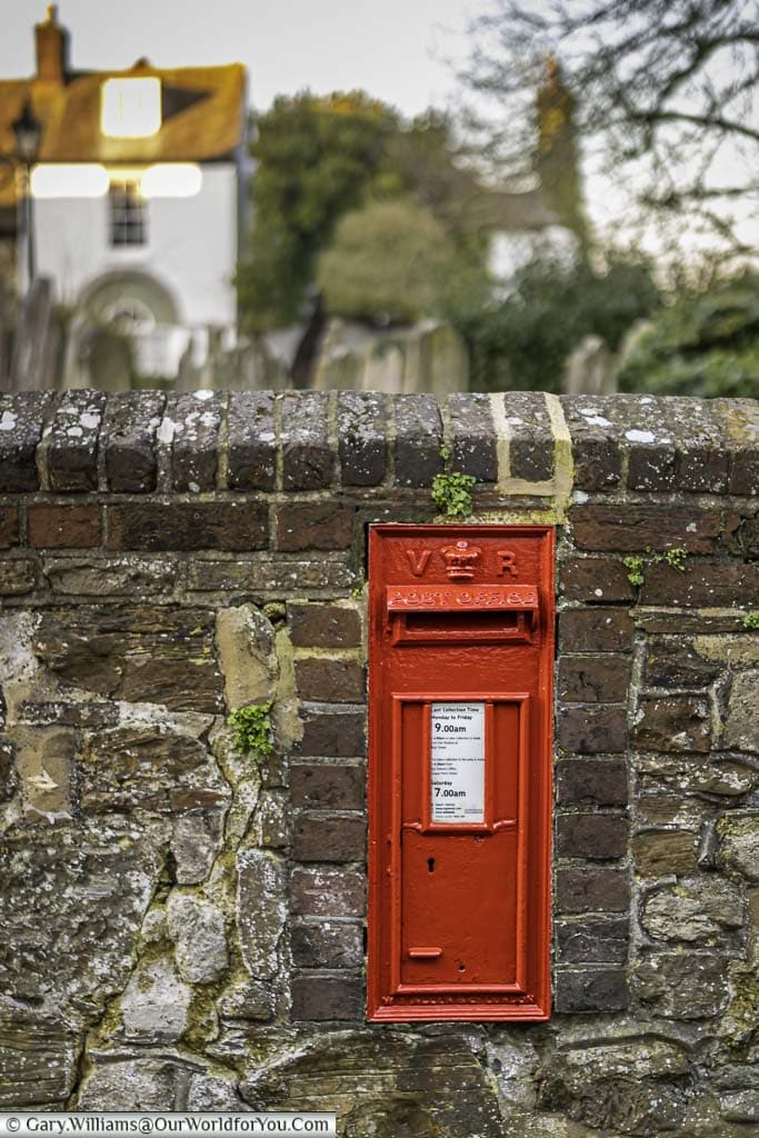 A victorian red letterbox set in the wall surrounding saint mary the virgin church in rye, east sussex