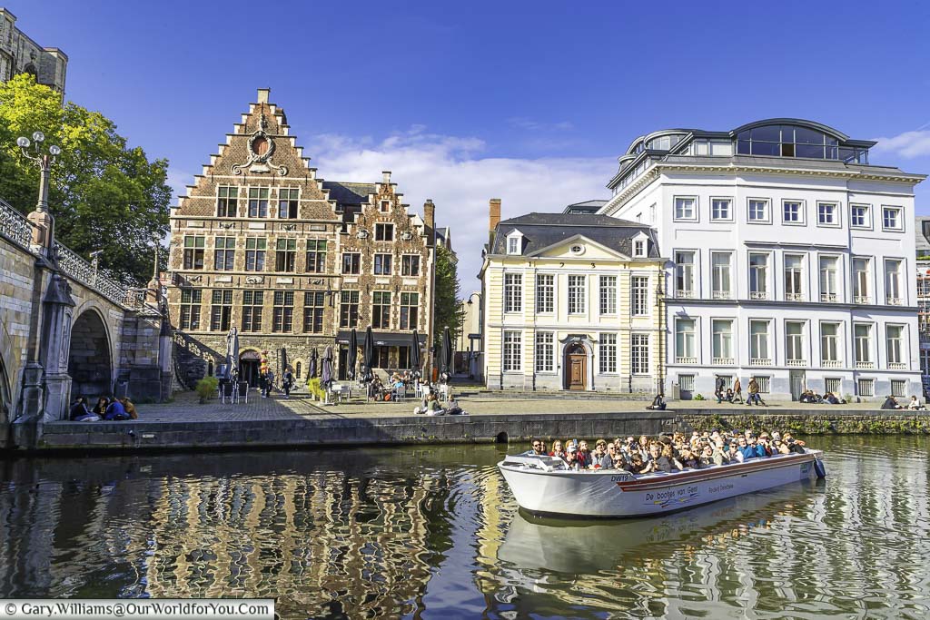 A sight-seeing boat between the Korenlei and Graslei sides of the quay in the centre of historic Ghent.