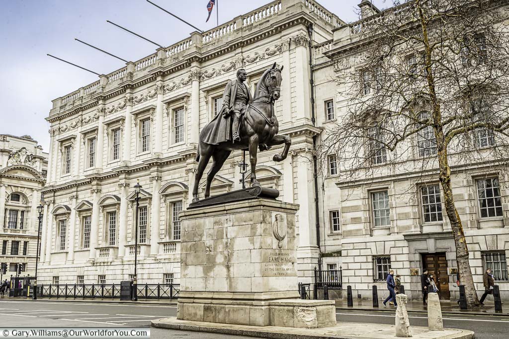 An equine statue of Field Marshal Earl Haig on a plinth in the centre of Whitehall with the Banqueting House in the background.