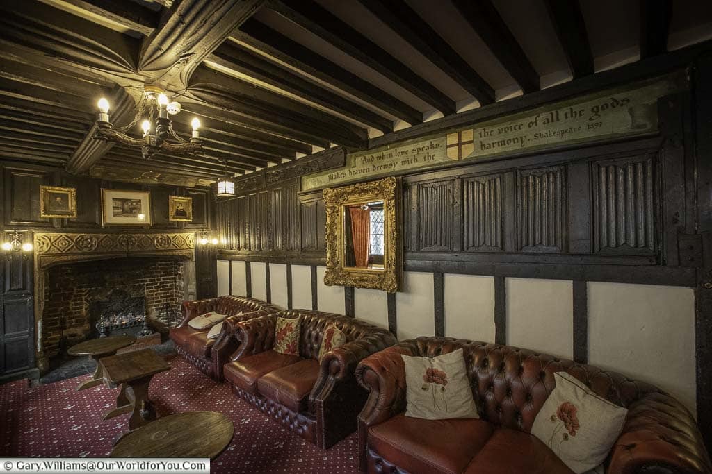 The Dr Syn's Chamber, with its deep red leather sofas and open fireplace beneath a dark timbered roof at the mermaid inn in rye, east sussex