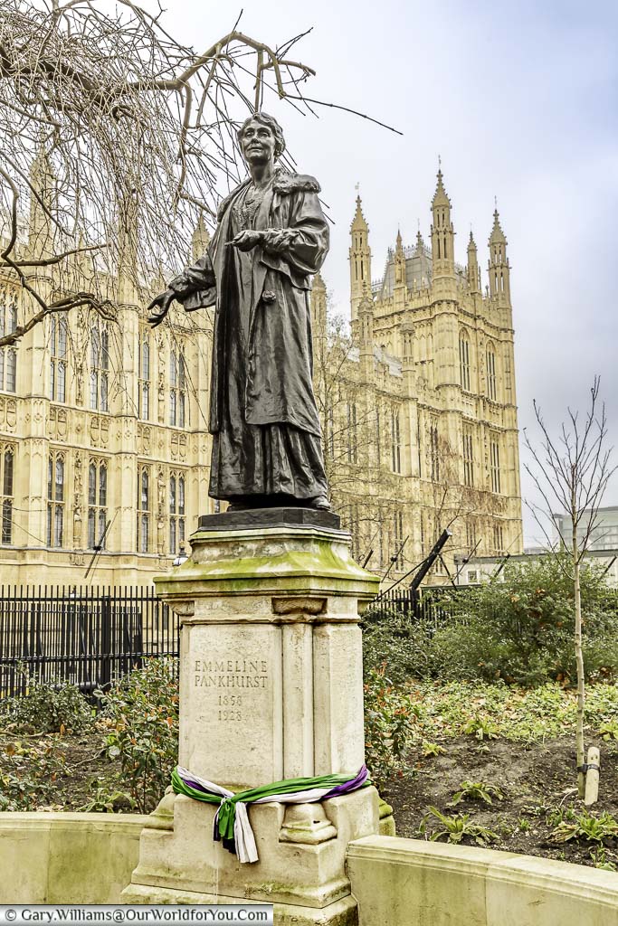 The bronze statue on a stone plinth to Emeline Pankhurst, the suffragette, on the edge of Victoria Tower Gardens next to the Palace of Westminster.