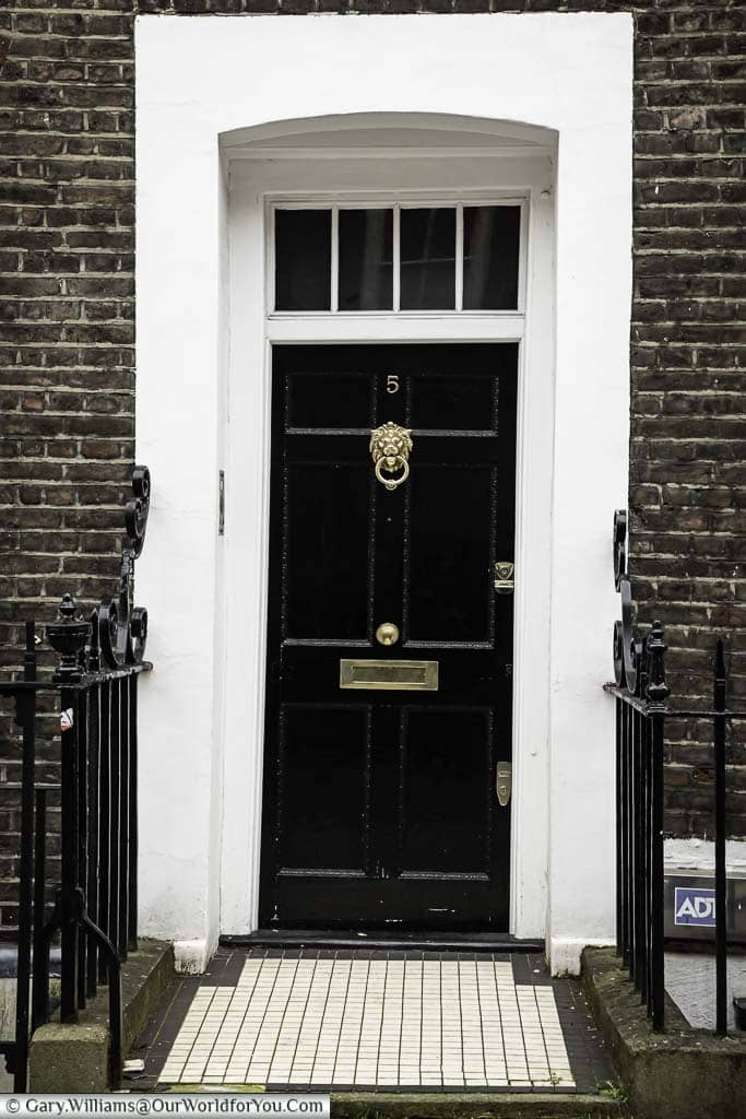 The front of number 5 Lord North Street, in Westminster, that was once home to British Prime Minister Harold Wilson. A traditional black wooden door with a polished brass lion's head door knocker with a painted white surround.