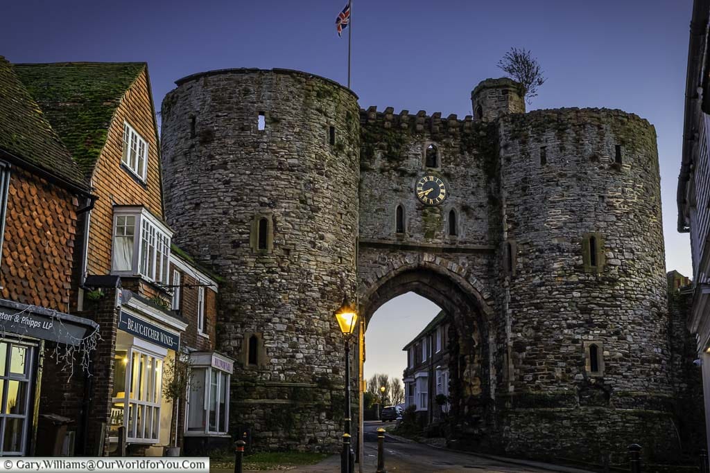 The street-side view of the medieval landgate rye in east sussex at dusk, once the street lanterns have come one