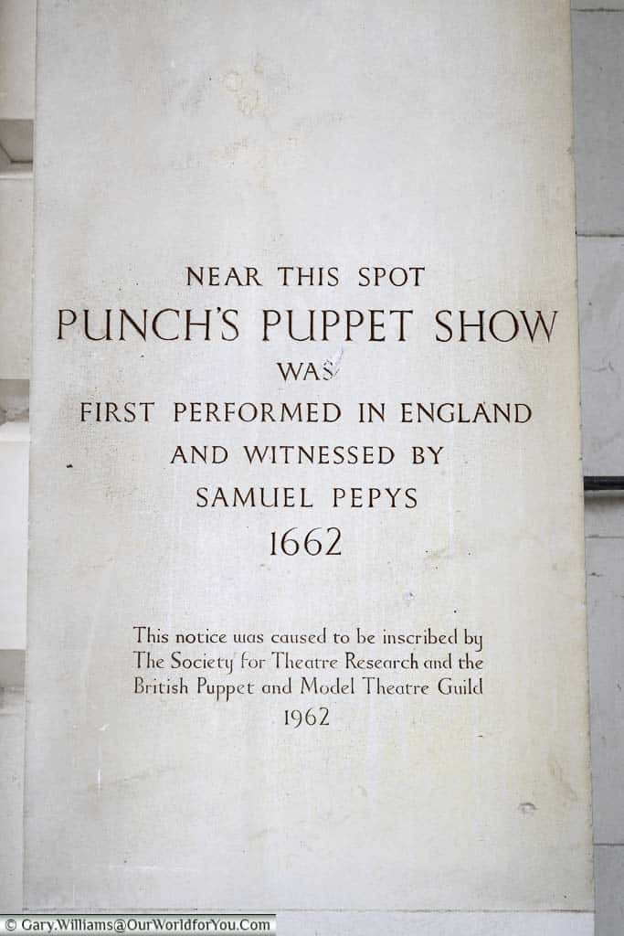 A stone tablet on st paul's church in covent garden, london, commemorating the first performance of a punch and judy show and witnessed by samuel pepys in 1662