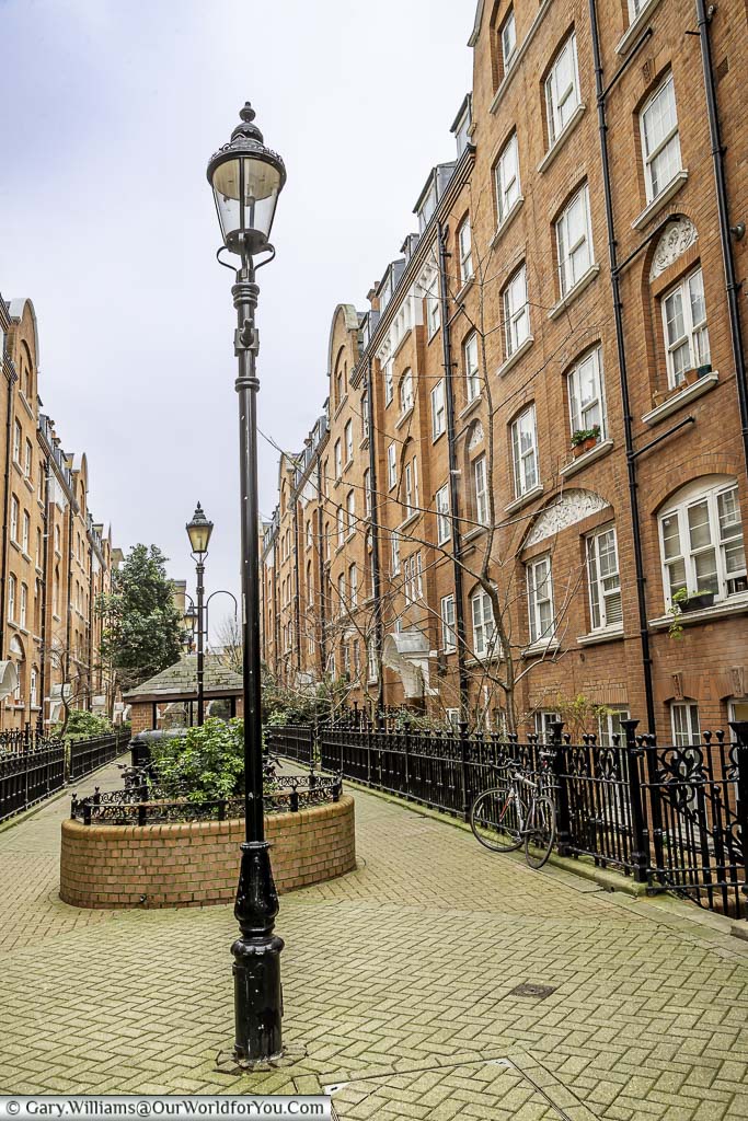 A courtyard between two apartment blocks with ornate, cast-iron, streetlamps in Regency Street, Westminster