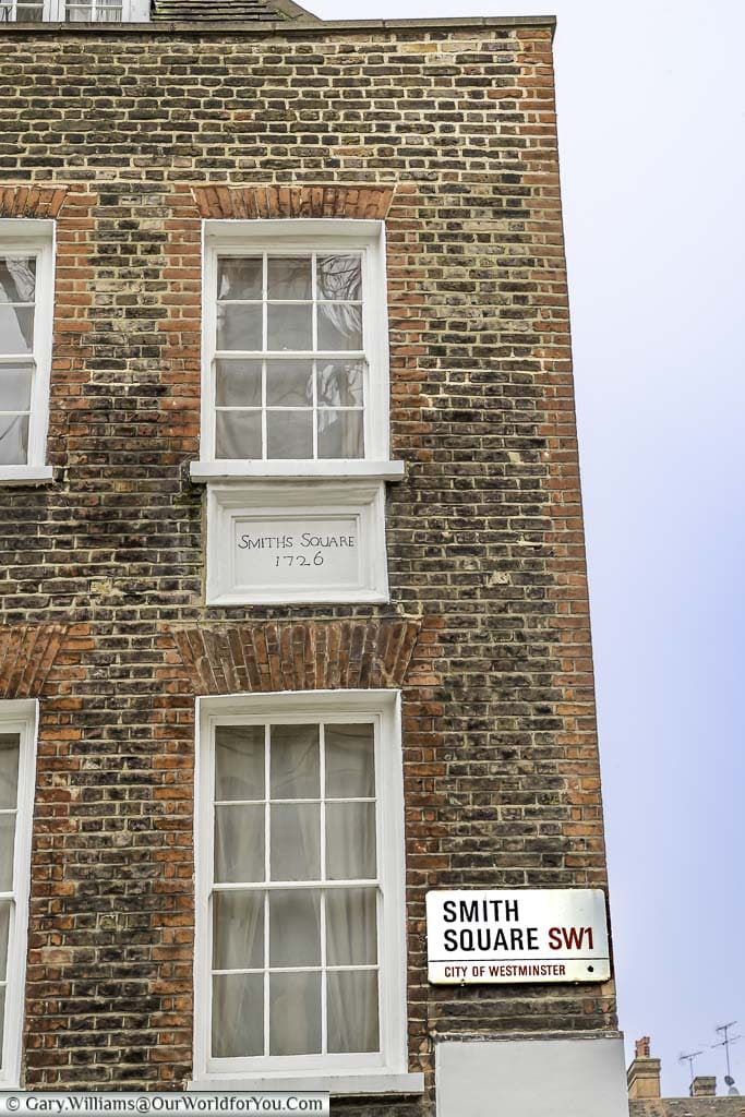 The corner of Smith Square, showing the original street sign from 1726, in addition to a more modern one.