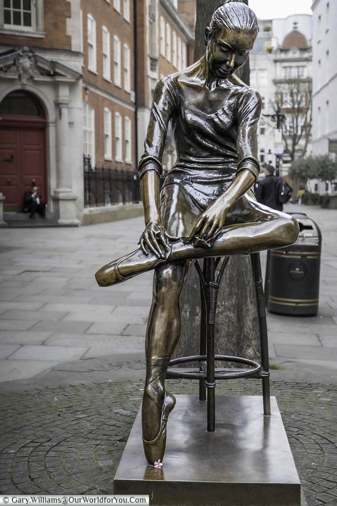 The bronze ballerina statue on a stool in broad court in london's covent garden district