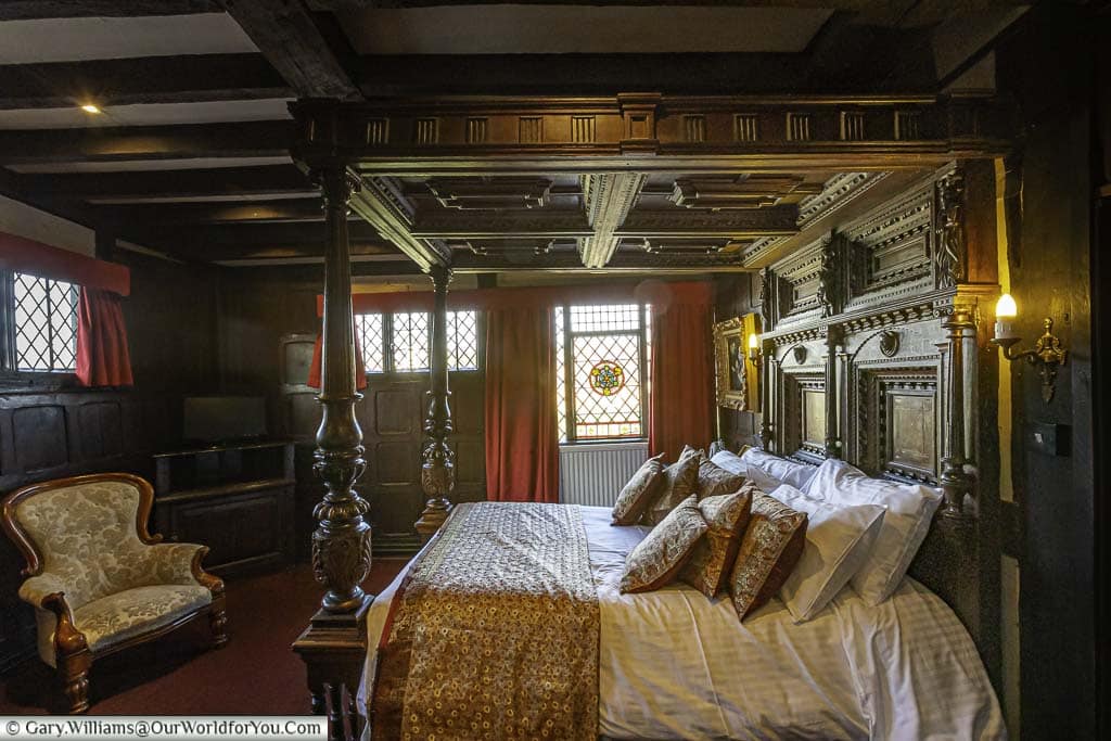 A large dark oak carved four-poster bed in the Elizabethan bed chamber at the Mermaid Inn in rye, east sussex