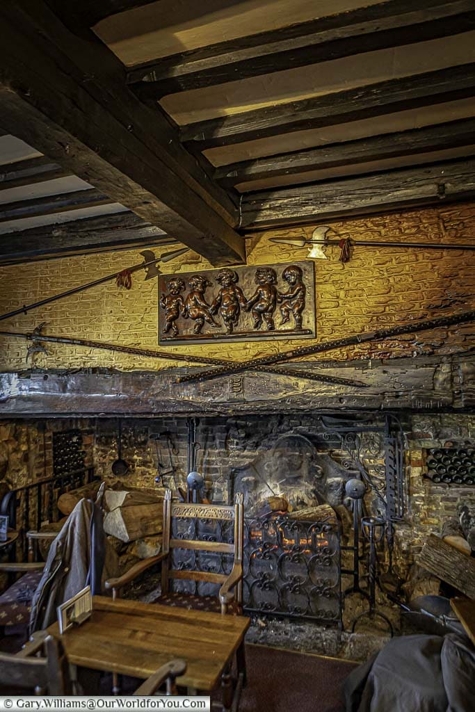 The rustic-looking medieval Giants' fireplace with dark heavy timbers with a roaring fire