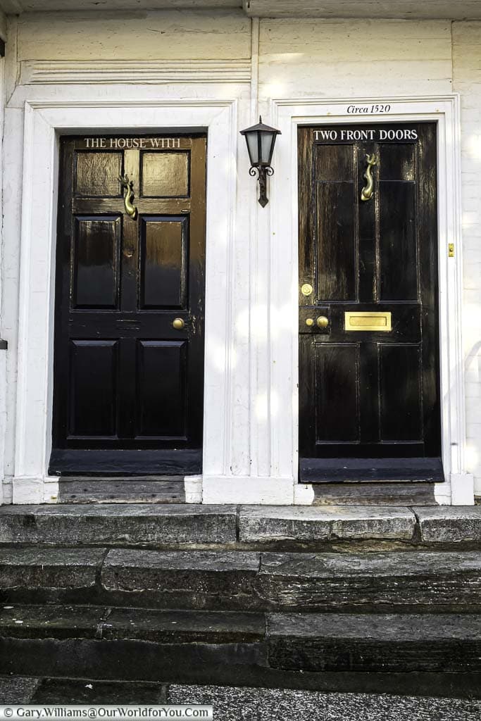 The two black wooden front doors, only one with a letterbox, for the 'House with Two Front Doors' from circa 1520 in mermaid street in rye, east sussex
