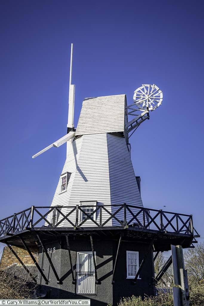 A white weatherboarded windmill on a black base in rye, east sussex