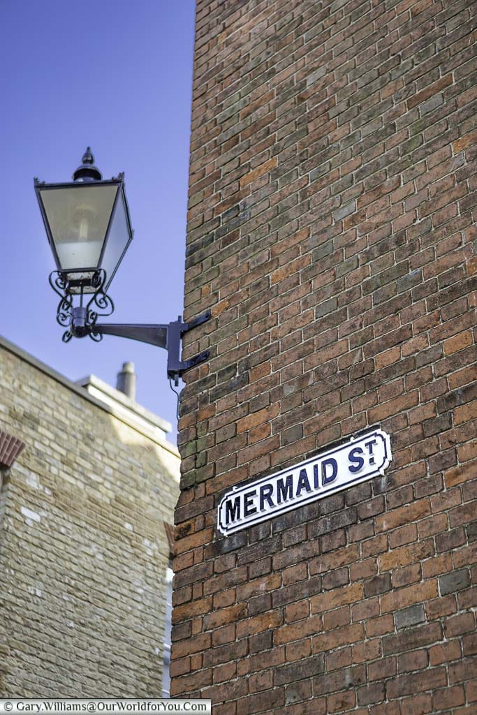 An iron lantern above a sign for mermaid street in rye, east sussex