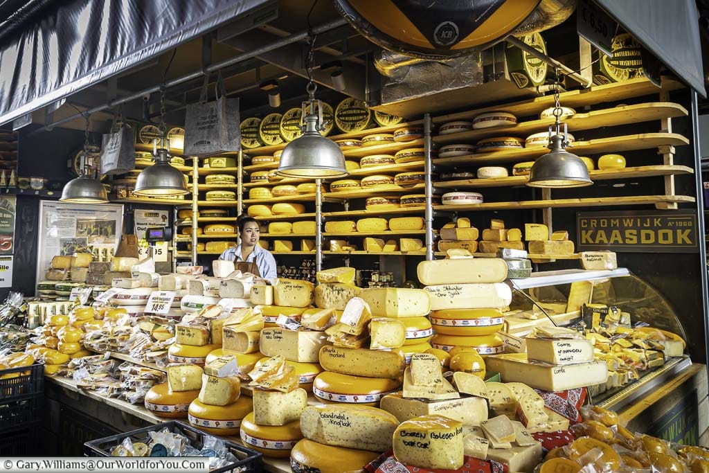 A cheese stall stacked with whole cheeses in the market hall in central rotterdam