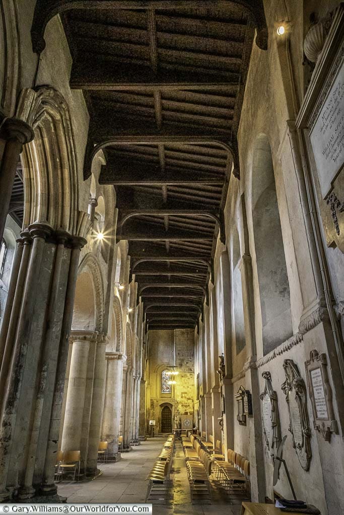 A look along the corridors next to the nave of rochester cathedral with its exposed wooden ceiling.