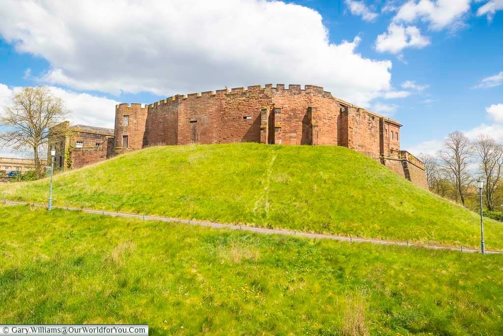 The historic red brick chester castle atop a grassy mount in central chester