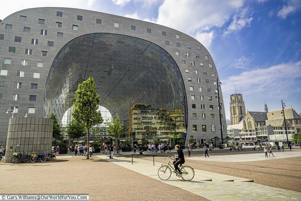 A cyclist riding in front of the modernist Markethall in Rotterdam