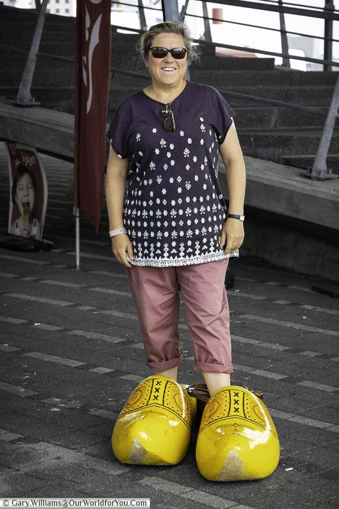 Janis standing in a pair of giant yellow clogs on the harbourside of rotterdam