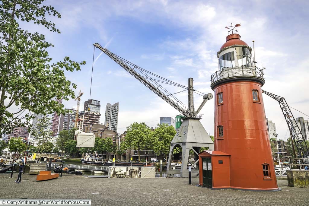 The bright red lighthouse and dock crane at rotterdam's maritime museum