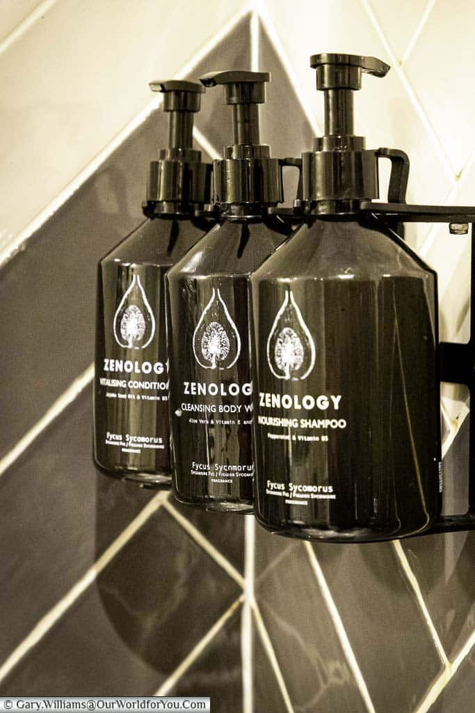 Three refillable bottles of luxury Zenology bath products in the shower of our king deluxe room at the hotel indigo chester