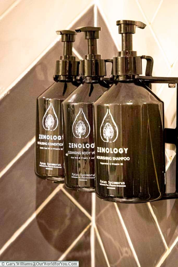 Three refillable bottles of luxury Zenology bath products in the shower of our king deluxe room at the hotel indigo chester