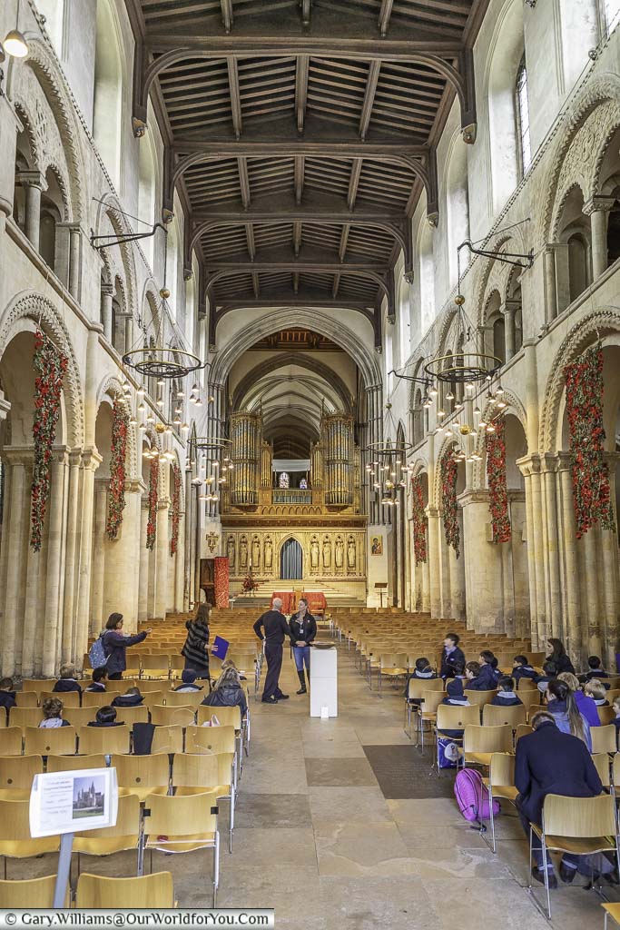 A look along the nave of rochester cathedral with its high stone columns and vaulted wooden ceiling towards the cathedral organ.