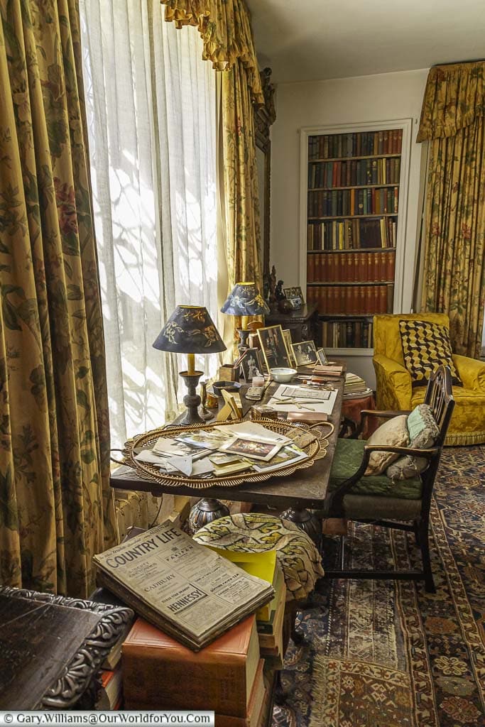 A cluttered desk belonging to anne mussel in the library of nymans