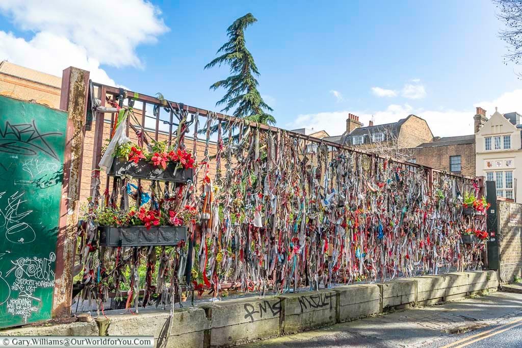 The railings of bankside's crossbones graveyard adorned with memorial ribbons for the souls remembered in the cemetery in London