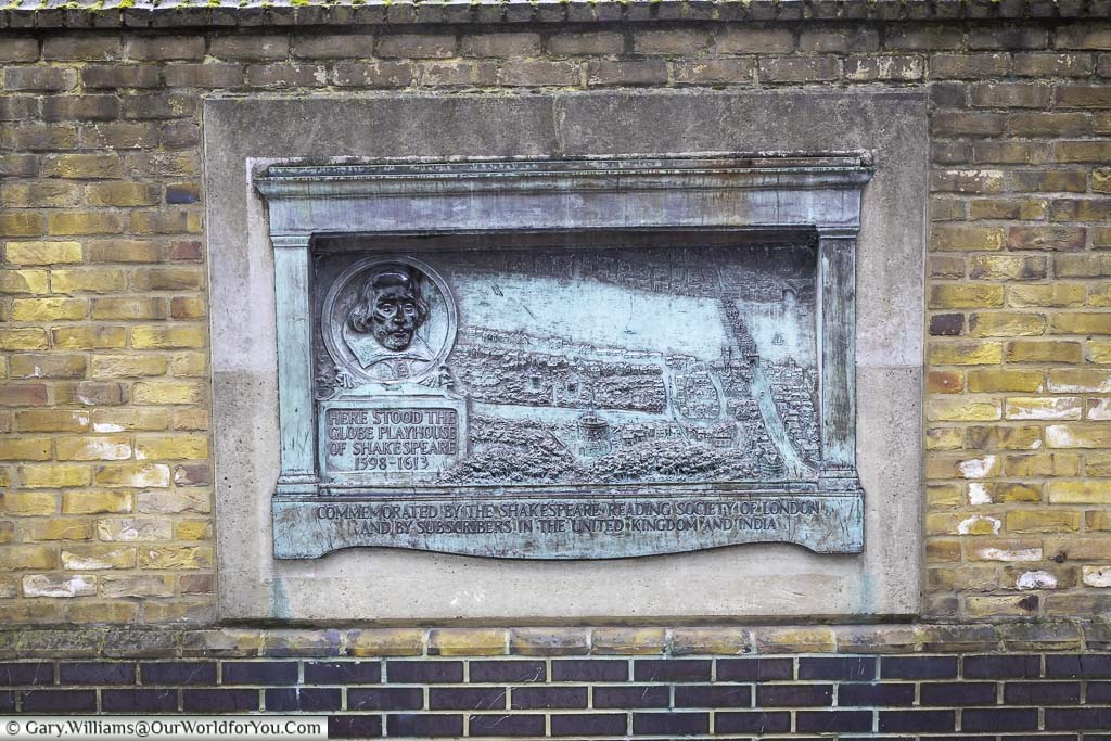 A verdigris coloured brass plaque mounted on a wall marking the spot of william shakespeares original globe theatre
