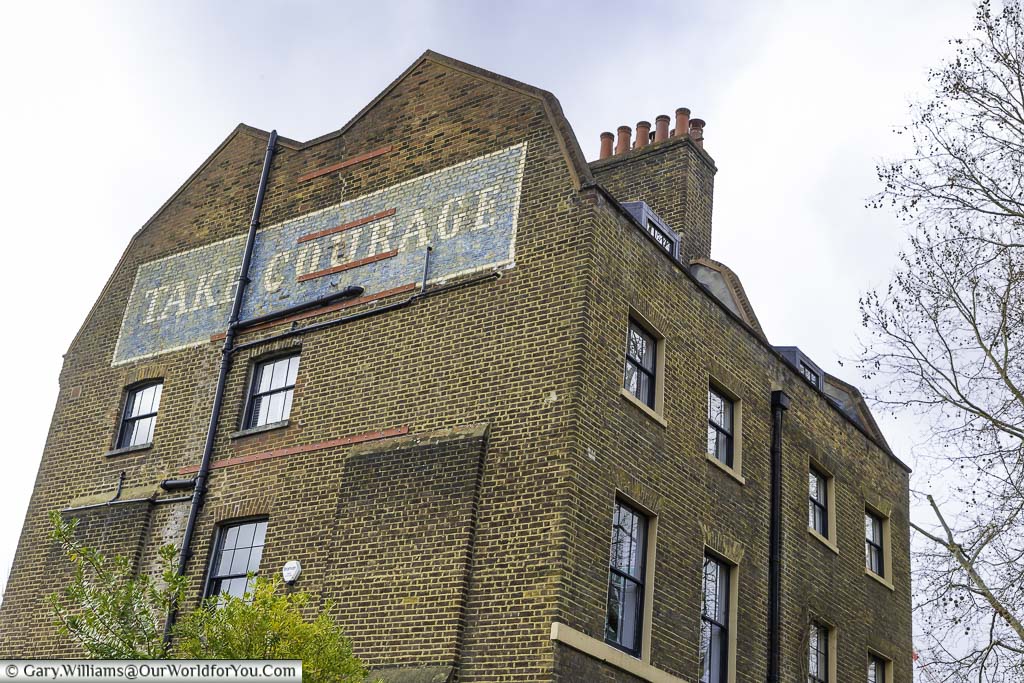 A take courage brewery advertisement painted on the side of a historic bankside's property
