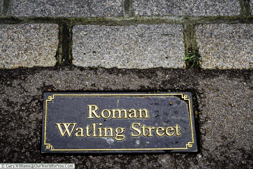 A metal plaque set in the path over Watling Street, the ancient Roman road from Dover to London