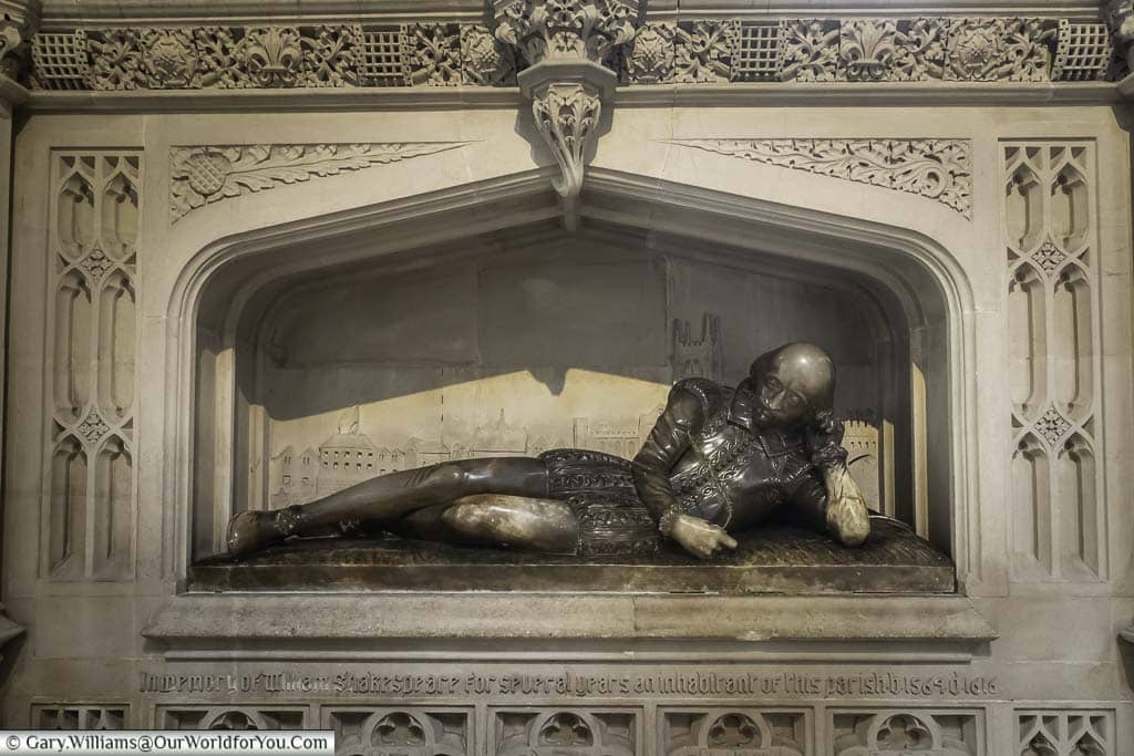 A memorial to williams shakespeare inside southwark cathedral on london's bankside featuring a full-size alabaster figure in a recumbent postion set in an alcove against a backdrop of the original globe theatre