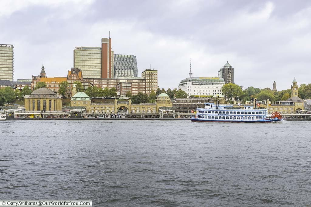 A paddle steamer on the elbe river in front of the landungsbrücken piers, against the backdrop of the St Pauli district of hamburg, germany