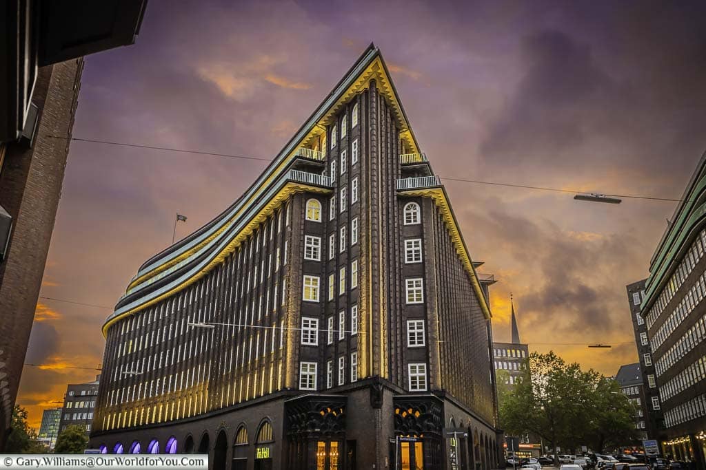 The sharp end of the Chilehaus office building at dusk under mauve to purple skies. This stylish 10-storey office block looks like a vision of the future as seen from the 1920s.