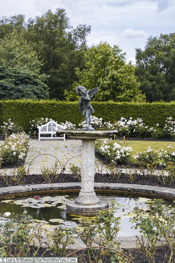 A bronze nymph atop a fountain at the centre of the rose garden at emmets gardens in kent