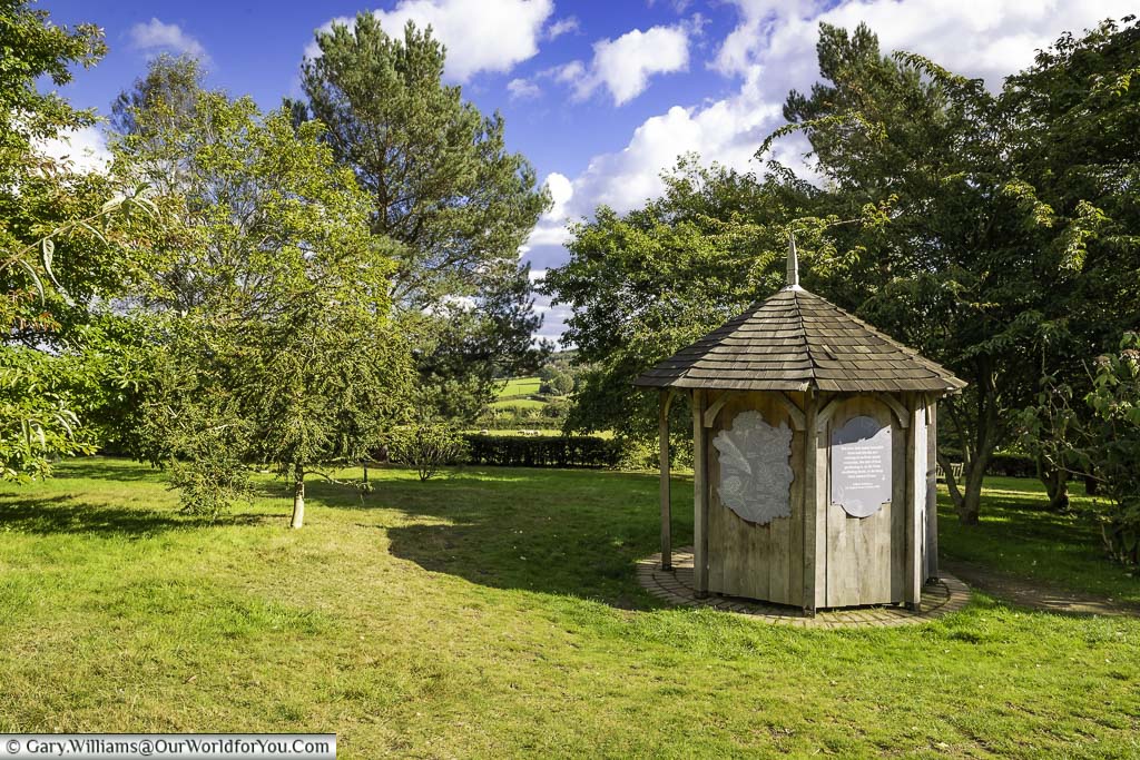 A small wooden gazebo overlooking the kent countryside in the south garden at emmets gardens