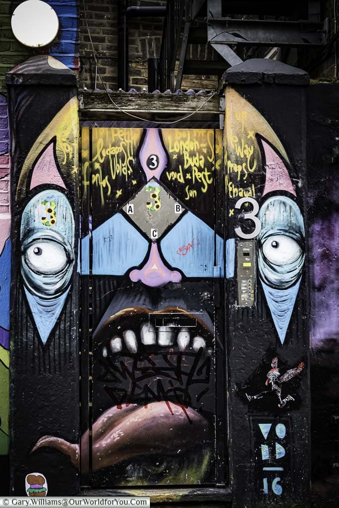 Street Art by Void 16 on a back gated in Hawley Mews, Camden