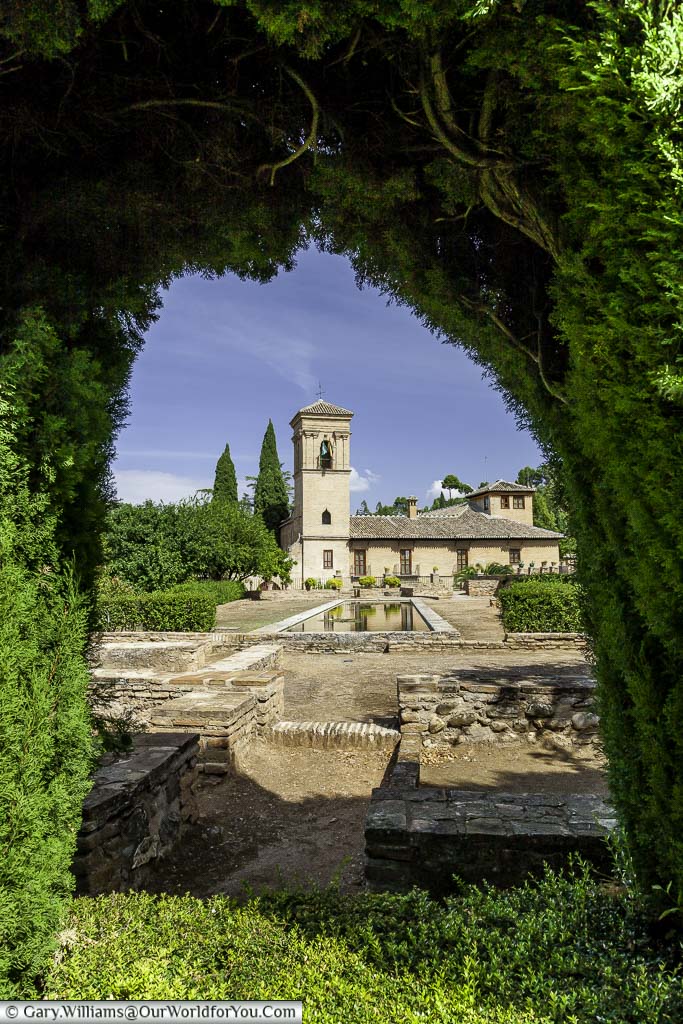 A view through a hedge to the Parador de Granada.