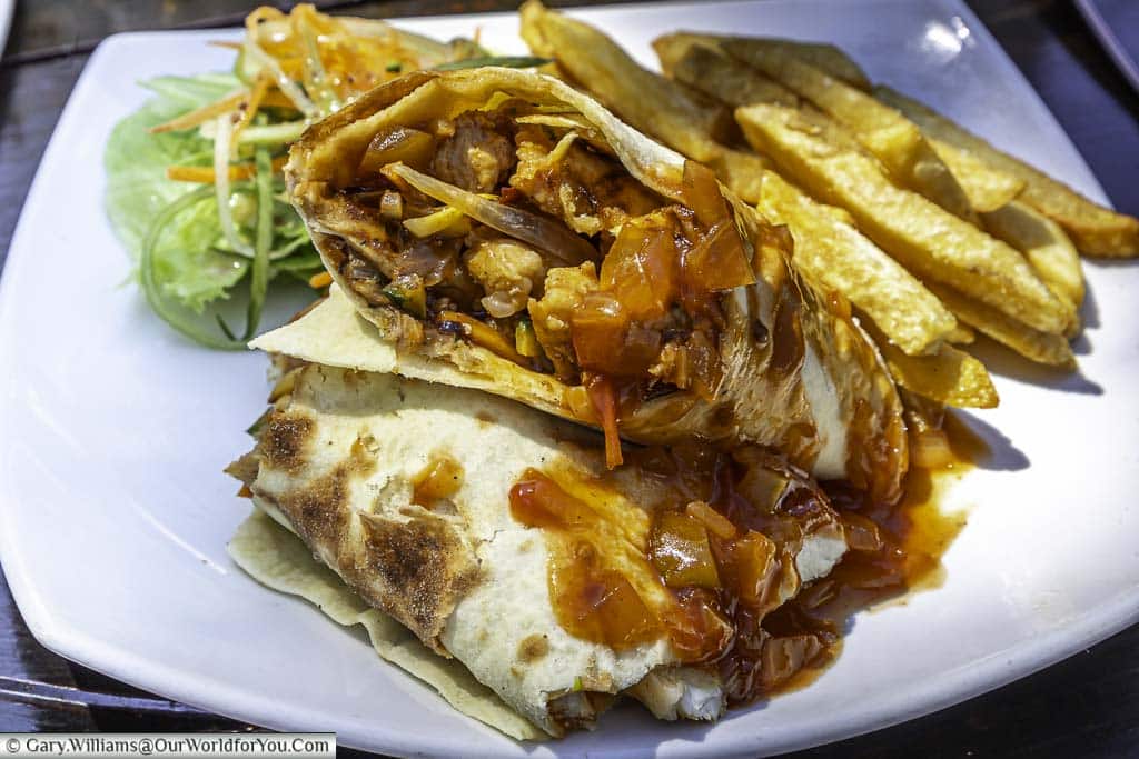 A crocodile wrap, cut in half and served with a sauce & fries in Zimbabwe